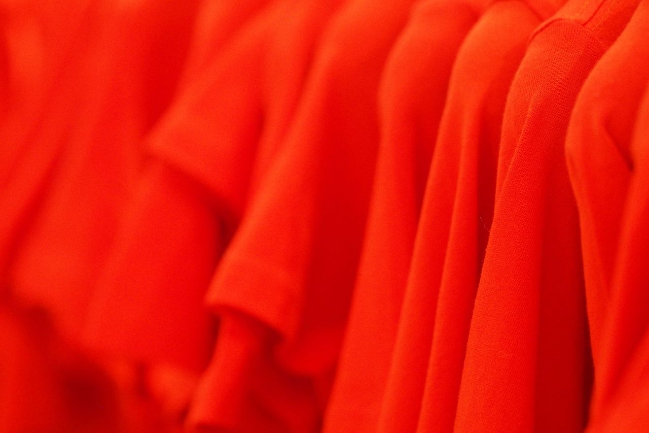 Crafting Captivating Headlines: Your awesome post title goes here Vibrant red T-shirts aligned on a rack, showcasing textile texture and fashion colors.
